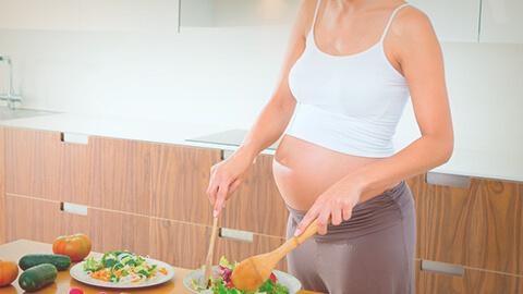 mujer embarazada cocinando